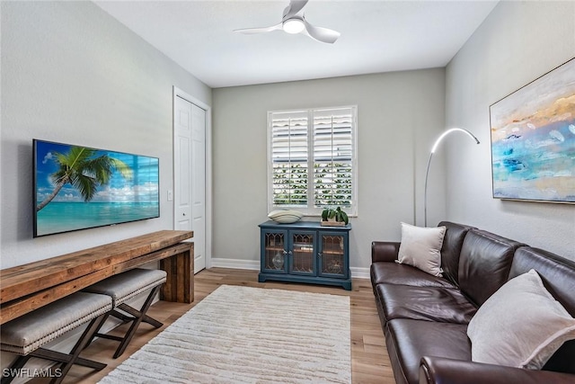 living area featuring ceiling fan, wood finished floors, and baseboards