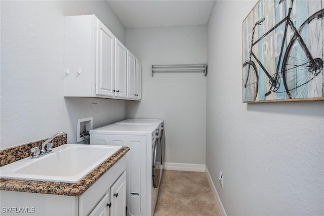 clothes washing area featuring cabinet space, baseboards, separate washer and dryer, a sink, and light tile patterned flooring