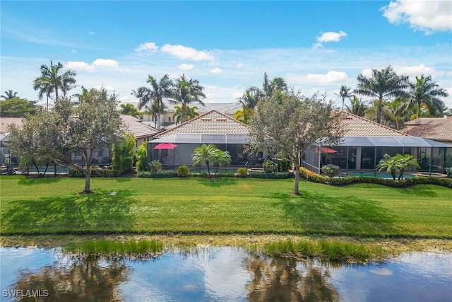 exterior space featuring a lawn, a water view, and a lanai