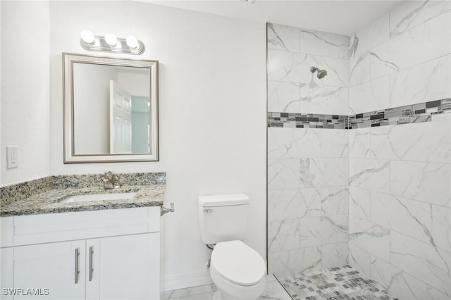 full bathroom featuring marble finish floor, toilet, a tile shower, vanity, and baseboards