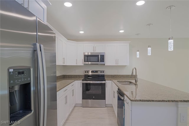 kitchen featuring light stone countertops, stainless steel appliances, white cabinetry, pendant lighting, and a sink