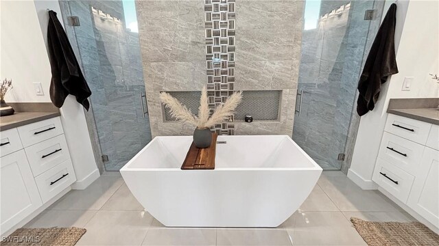 full bath with a soaking tub, vanity, a shower stall, and tile patterned floors