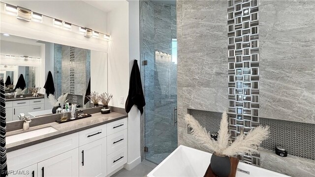 bathroom with a stall shower, a soaking tub, and vanity