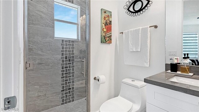 bathroom with toilet, a stall shower, and vanity