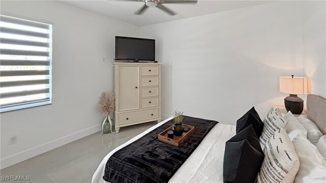 living area with ceiling fan, concrete floors, and baseboards