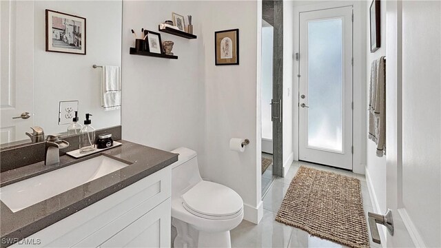 bathroom featuring toilet, tile patterned flooring, and vanity