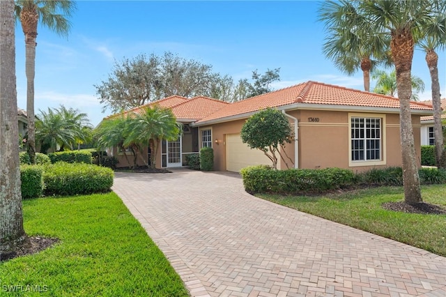 view of front of house with an attached garage, a tiled roof, decorative driveway, and stucco siding