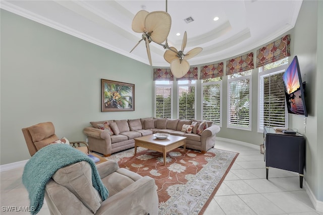 living room featuring light tile patterned floors, visible vents, a raised ceiling, ceiling fan, and crown molding