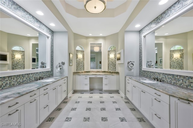 bathroom featuring tasteful backsplash, baseboards, and a sink