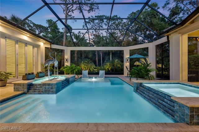 pool at dusk with a lanai and a pool with connected hot tub