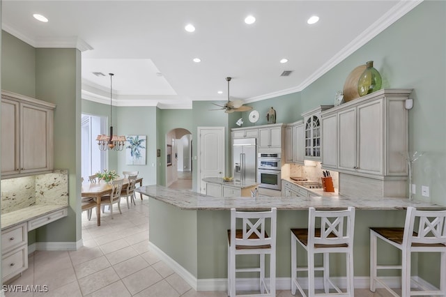 kitchen featuring arched walkways, light tile patterned floors, stainless steel appliances, visible vents, and crown molding