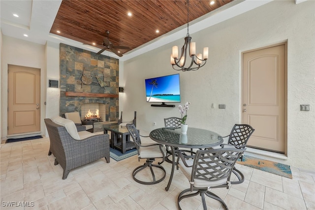 dining area featuring wooden ceiling, recessed lighting, a ceiling fan, and a stone fireplace