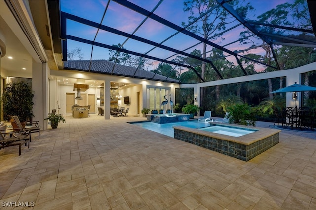 view of swimming pool with a patio area, a pool with connected hot tub, and glass enclosure