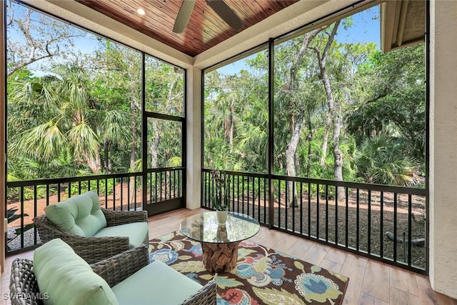 sunroom / solarium with a ceiling fan and wooden ceiling