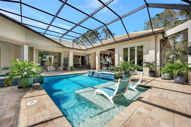 view of swimming pool featuring a pool with connected hot tub, a patio area, and a lanai