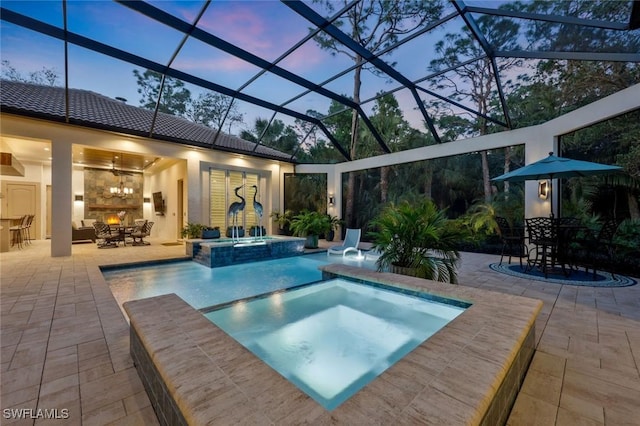 view of swimming pool featuring outdoor dining space, a patio area, a lanai, and a pool with connected hot tub