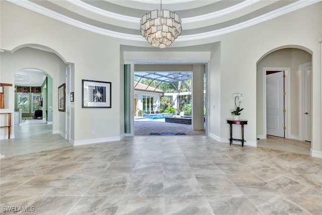 entrance foyer with ornamental molding, a tray ceiling, a sunroom, and baseboards