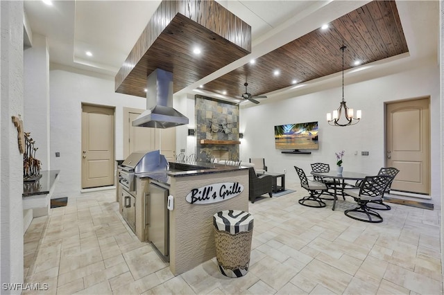 kitchen featuring dark countertops, wood ceiling, a raised ceiling, and island exhaust hood