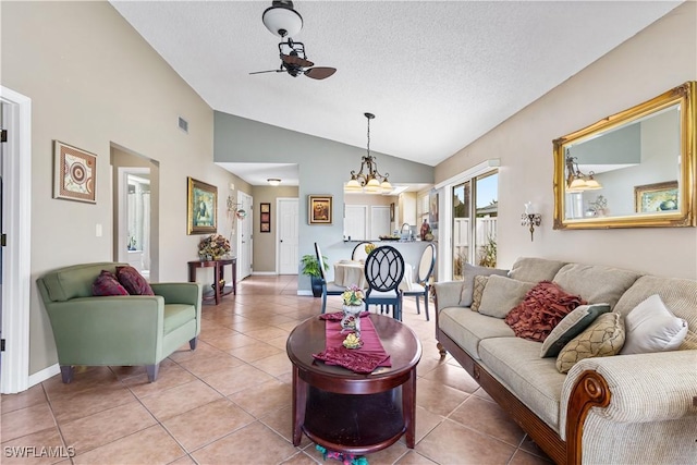 living area featuring a ceiling fan, lofted ceiling, light tile patterned flooring, and a textured ceiling