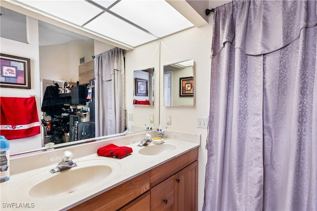 full bathroom with double vanity and a sink