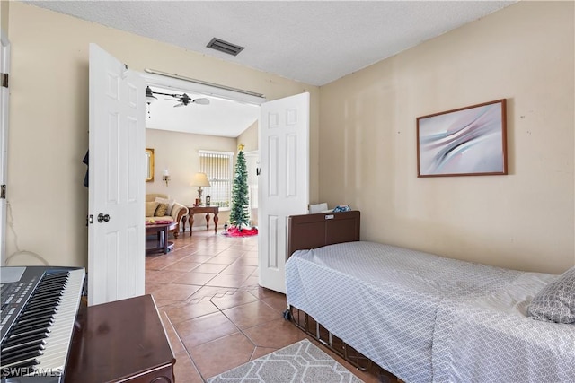 tiled bedroom with visible vents and a textured ceiling