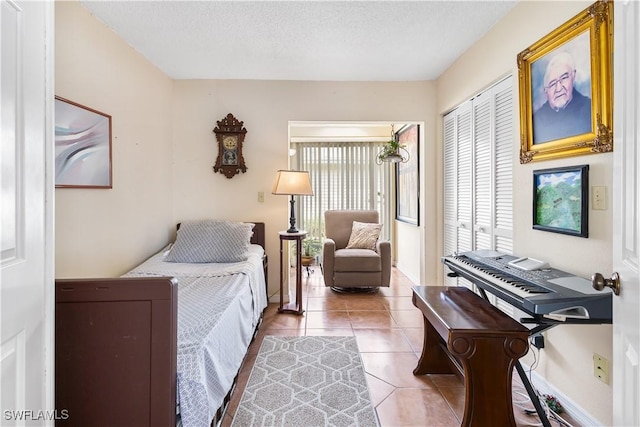 bedroom featuring light tile patterned floors, a textured ceiling, and a closet