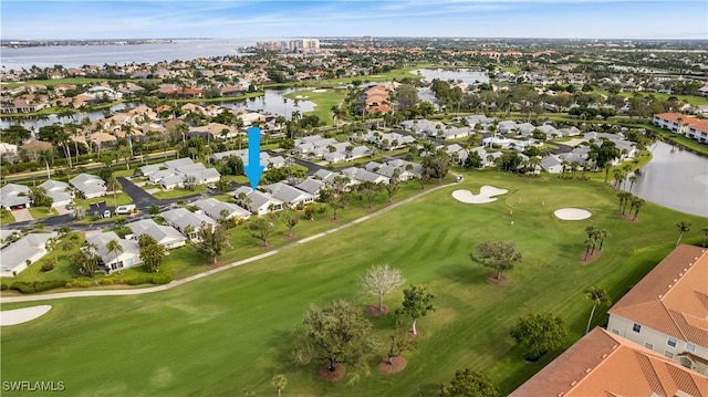 drone / aerial view featuring view of golf course, a water view, and a residential view