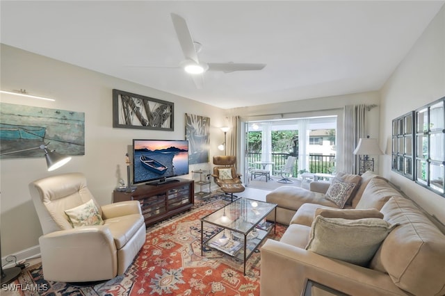 living room with ceiling fan and baseboards