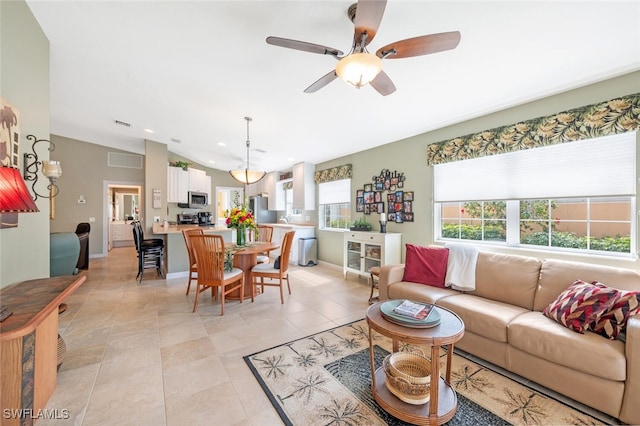 living room with lofted ceiling, light tile patterned floors, visible vents, and baseboards