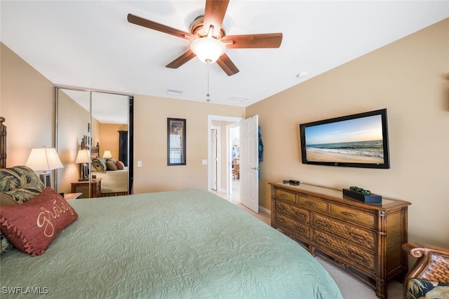 bedroom featuring a ceiling fan, a closet, visible vents, and light carpet