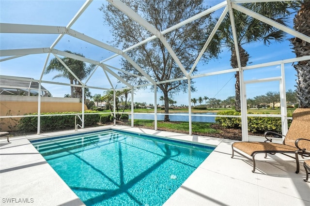 outdoor pool with a patio area, glass enclosure, and a water view