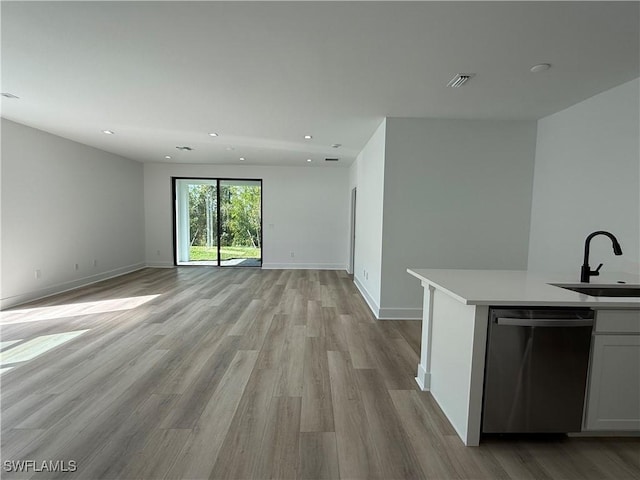 kitchen featuring light hardwood / wood-style flooring, white cabinetry, sink, and stainless steel dishwasher