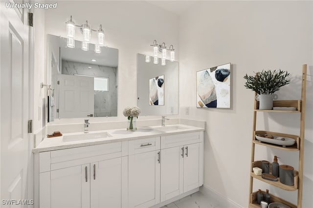 full bathroom featuring marble finish floor, double vanity, a sink, and a marble finish shower