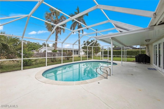 view of swimming pool with a yard, glass enclosure, a patio, and area for grilling