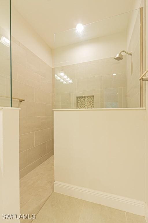 bathroom with tile patterned flooring and tiled shower