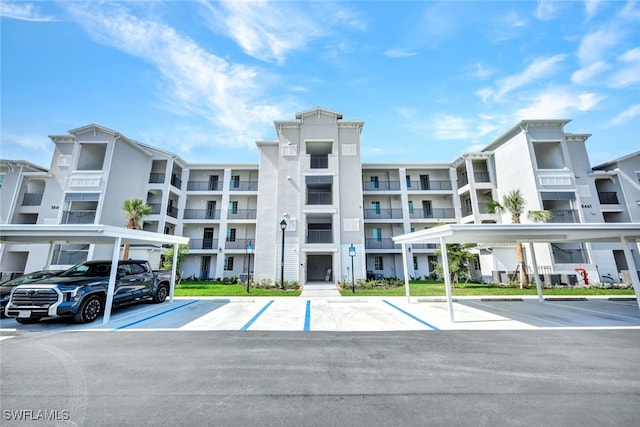 view of property featuring covered and uncovered parking