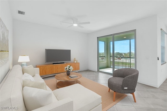 living area featuring visible vents, ceiling fan, baseboards, and light tile patterned flooring