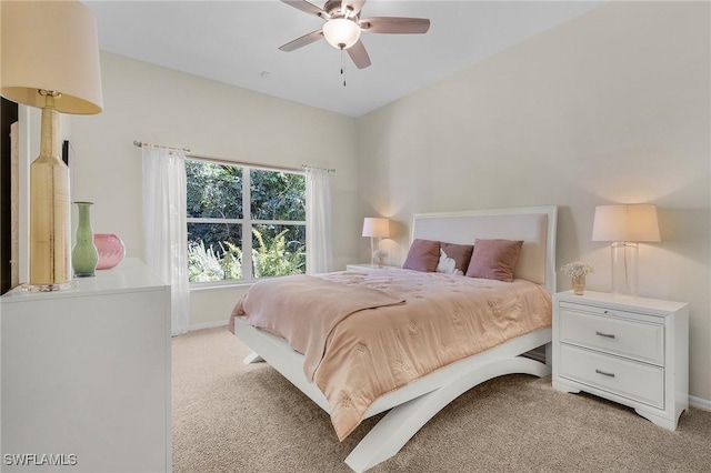 bedroom with light colored carpet, ceiling fan, and baseboards