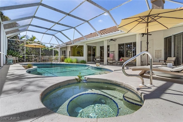 view of swimming pool featuring ceiling fan, a patio, glass enclosure, and a pool with connected hot tub