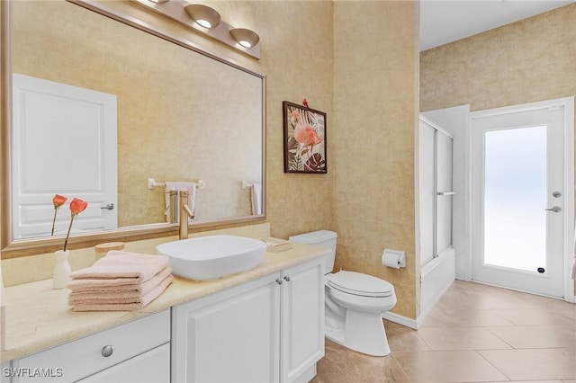 bathroom with shower / bath combination with glass door, vanity, toilet, and tile patterned floors