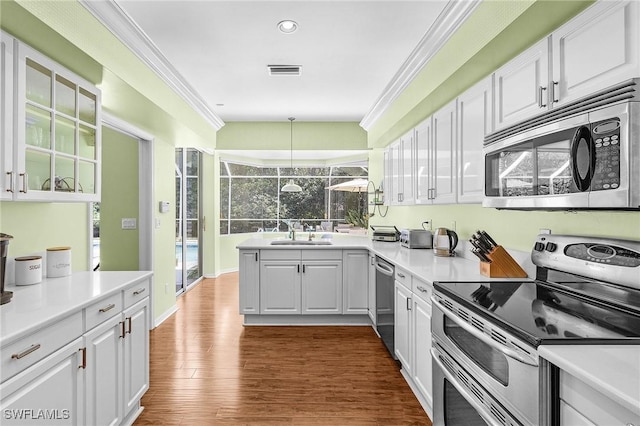 kitchen featuring a sink, visible vents, white cabinets, ornamental molding, and appliances with stainless steel finishes