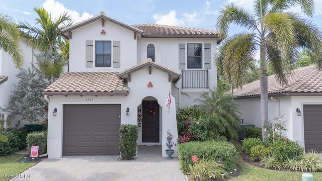 mediterranean / spanish-style home with stucco siding, decorative driveway, and a tiled roof