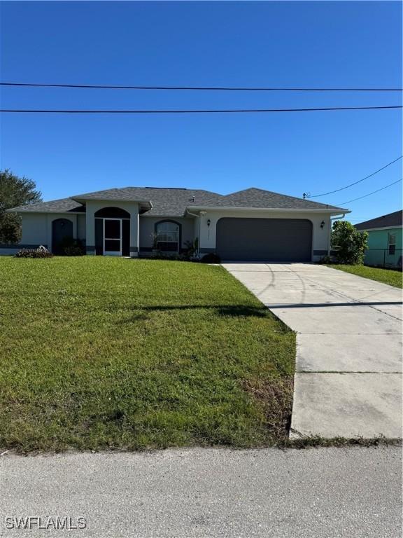 single story home with a front yard and a garage