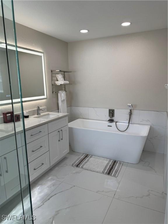 bathroom with vanity and a washtub