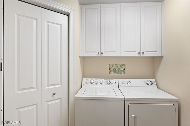 clothes washing area featuring washer and dryer and cabinet space