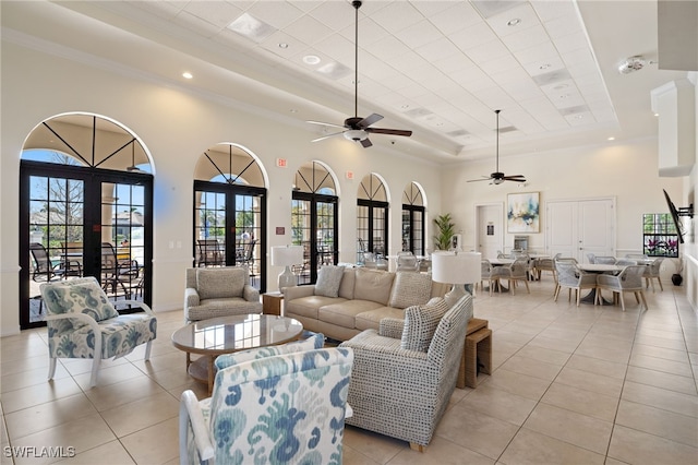 living room featuring light tile patterned floors, recessed lighting, a towering ceiling, french doors, and a raised ceiling