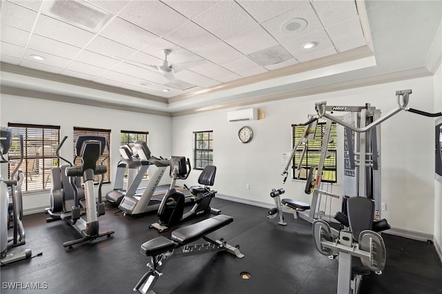 gym with a paneled ceiling, baseboards, a tray ceiling, and a wall mounted AC