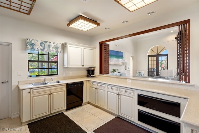 kitchen with a healthy amount of sunlight, black dishwasher, light countertops, and a sink