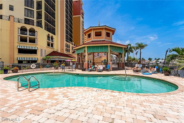 pool featuring a patio area, fence, and a gazebo