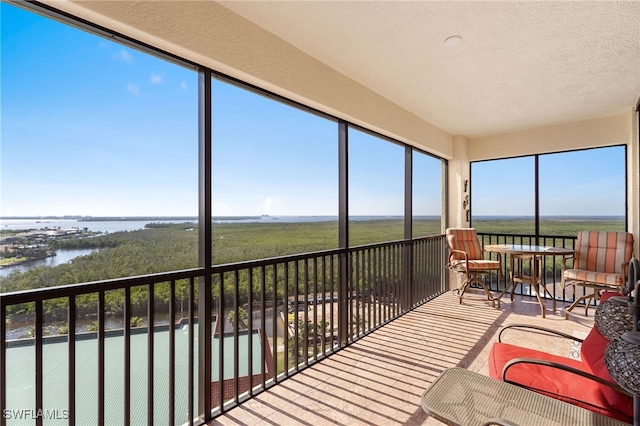 sunroom / solarium featuring a water view